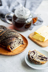  Poppy seed roll with butter and tea. Baking with poppy seeds. The work of the baker. Baking rolls with poppy seeds and pies in the kitchen. Bakery, cook together.