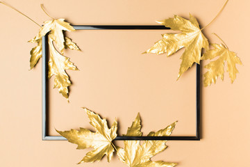 Fall and autumn flat lay with painted golden leaves on beige  background