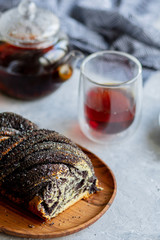 Poppy seed roll with butter and tea. Baking with poppy seeds. The work of the baker. Baking rolls with poppy seeds and pies in the kitchen. Bakery, cook together.