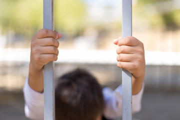 schoolboy holds cell and hopes for freedom or makes fun of the concept of life imprisonment