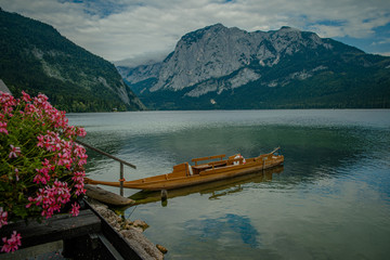 Obraz premium Mountain lake in Austrian Alps. beautiful view of the water surface and floating boats and kayaks