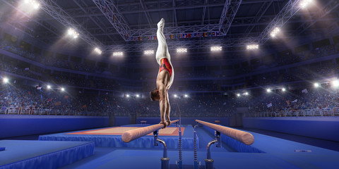Male athlete doing a complicated exciting trick on parallel bars in a professional gym. Man perform...