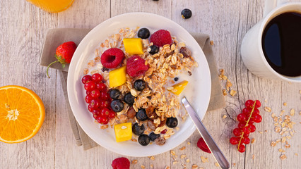 muesli, milk and fruit with coffee cup and orange juice