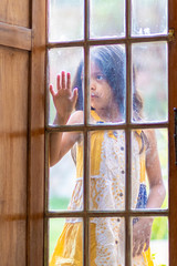 Brunette girl behind wooden and glass door