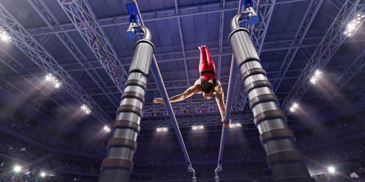 Male athlete doing a complicated exciting trick on parallel bars in a professional gym. Man perform stunt in bright sports clothes