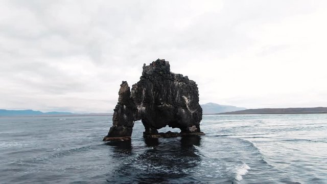 Aerial orbiting view of the famous animal-shaped stone on the sea in Hvitserkur, North Iceland
