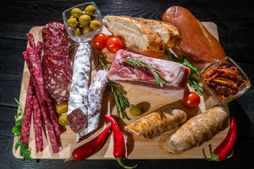 Various kind types of salami, speck and sausages on a wooden table