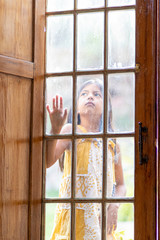 Brunette girl behind wooden and glass door