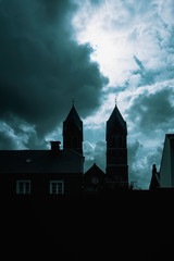 Silhouette of catholic church at night over dark sky background