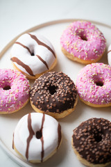 Colorful donuts on marble background with copy space