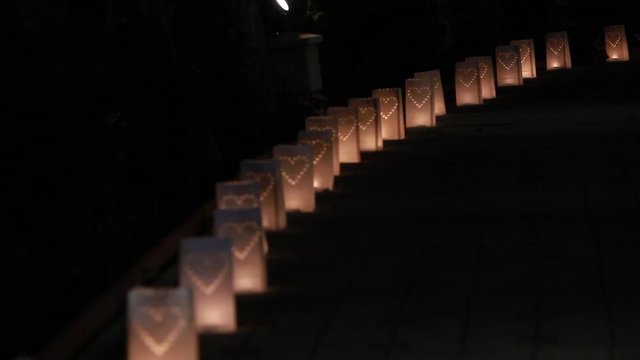 Paper bag lanterns on stairs. Candle light. Pierced in a heart shape. Romantic decoration