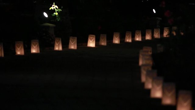 Paper bag lanterns on stairs. Candle light. Pierced in a heart shape. Romantic decoration