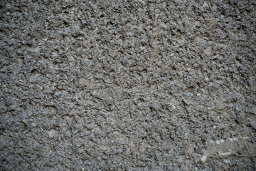 Texture of an old cracked concrete wall. Background image of a worn gray concrete surface