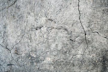 Texture of an old cracked concrete wall. Background image of a worn gray concrete surface