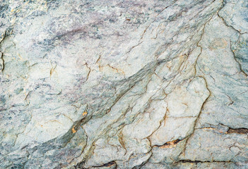 The texture of the stone overgrown with moss. Background image of a boulder