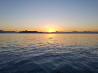 Dramatic sunset behind the mountains seen from the greek island of Aegina