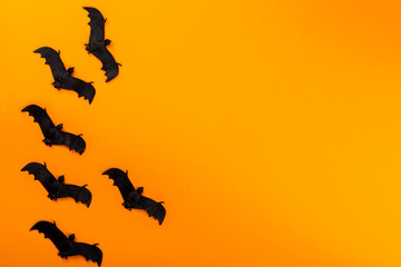 Fototapeta na wymiar Halloween postcard. Тraditional festival of autumn. Decoration and party concept .Bats on a orange background .Flat lay, top view, copy space
