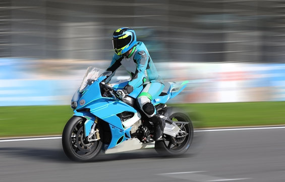 Motorcycle rider racing at high speed on race track