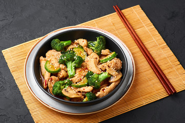 Hunan Chicken in black bowl at dark slate background. Hunan Chicken is chinese or indo-chinese...