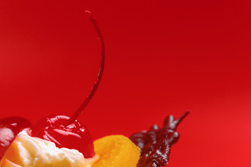 close-up of a delicious dessert, cupcake with cream, berries, fruit and chocolate, on a red background