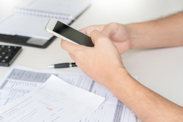 Man using calculator and calculate bills receipt in home expenses payments costs with paper note, financial account management and payment or saving concept.