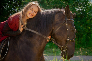 Fototapeta premium Beautiful caucasian young girl walking with a horse and enjoys summertime in countryside.