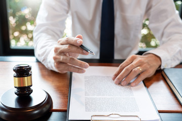 lawyer or judge business man working with paperwork agreement contract and gavel in Courtroom,...