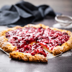 Bakery products. Summer pie with berries. Galeta with cherry sprinkled with powdered sugar.