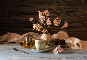 Useful, hot herbal tea, candy and flowering almond twigs close-up