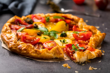 Summer cake with cherry tomatoes, brie cheese and basil. Baking dough with vegetables, greens.