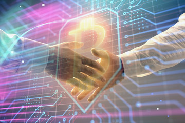 Multi exposure of bitcoin sign on abstract background with two men handshake. Concept of cryptocurrency