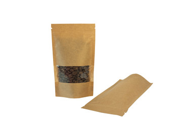 Brown kraft paper pouch bags with coffee beans front view on a wooden background. Packaging for...
