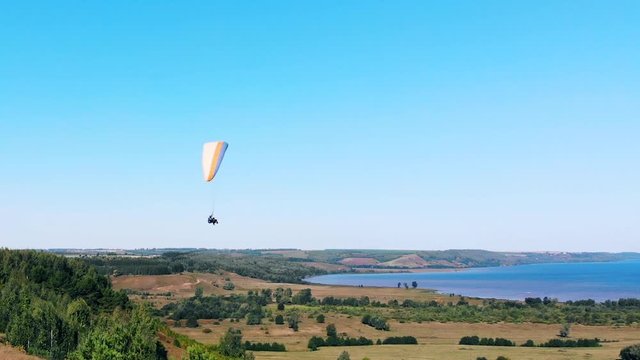 A person with a paraplane flying in the sky.