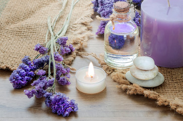 Obraz na płótnie Canvas Bottle with lavender essential oil , candle on wooden table.