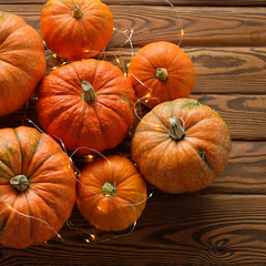 pumpkins with a shining garland on a wooden table