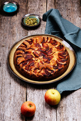 Eplekake. Traditional Norwegian apple cake or pie sprinkled sugar and cinnamon on old rustic wooden table. Autumn harvest of apples. Fika. Hygge