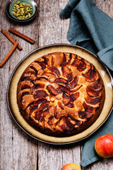 Eplekake. Traditional Norwegian apple cake or pie sprinkled sugar and cinnamon on old rustic wooden table. Autumn harvest of apples. Fika. Hygge