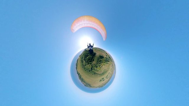 Man controls a yellow paraplane in the sky. 360 view.