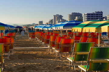 empty deck chairs in early morning at end of season at rimini beach italy