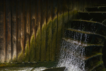 Working watermill wheel with falling water in the village © Julia