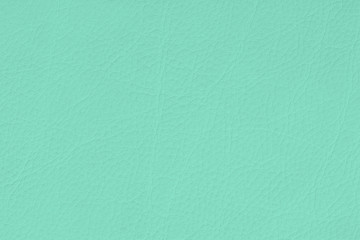Texture of genuine grainy leather of light mint green color for wallpaper or banner design. Fashionable modern background
