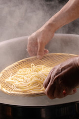 The bamboo pole picks up the hot noodles in the cauldron, and the noodle teeth have an appetite