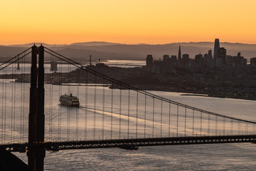 Fototapeta premium Golden Gate bridge in silhouette with a cruise ship coming into the San Francisco bay area 