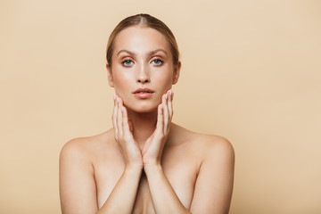 Image of alluring half-naked woman touching her face