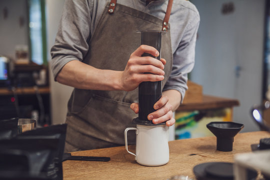 Aeropress coffee close-up: barista press to device and coffee drops pours  trought aeropress to pot. Alternative coffee brewing method. Vertical photo  Stock Photo - Alamy