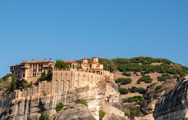 Monastery Meteora Greece. Stunning  panoramic landscape. View of mountains and green forest against epic blue sky with clouds. UNESCO heritage object.
