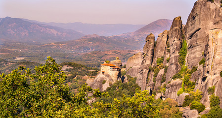 Monastery Meteora Greece. Stunning  panoramic landscape. View of mountains and green forest against epic blue sky with clouds. UNESCO heritage object.