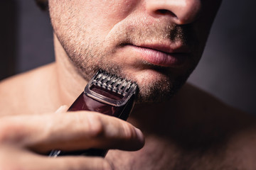 Close up modeling a beard and bristles with an electric shaving trimmer