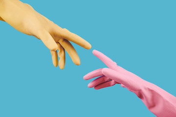 Hands of people in colorful rubber gloves reaching out for each other