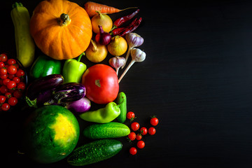 Autumn harvest from fresh seasonal vegetables on black wooden table. Thanksgiving day background with copy space. Assorted fresh vegetables. Detox, vegan and cleaning diet.